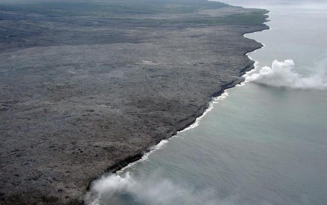 Photo: Courtesy of Hawaii Volcano Observatory. View across the coastal plain of Kilauea Volcano, showing two active ocean entries (white plumes).
